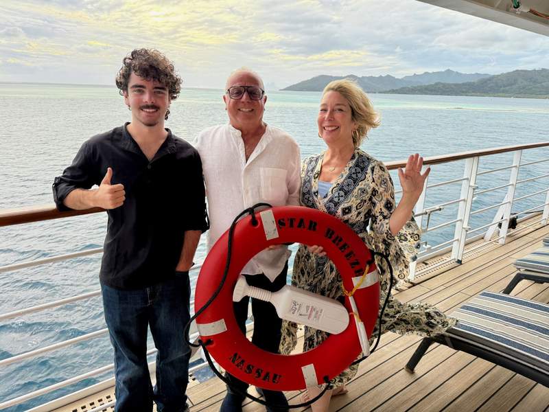 Author’s family holding the life buoy on deck of Star Breeze ship