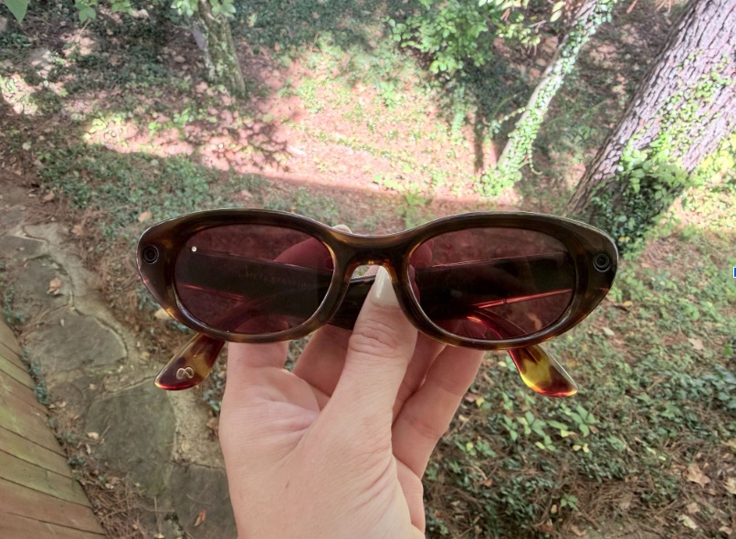 woman's hand holding a pair of Meta AI glasses