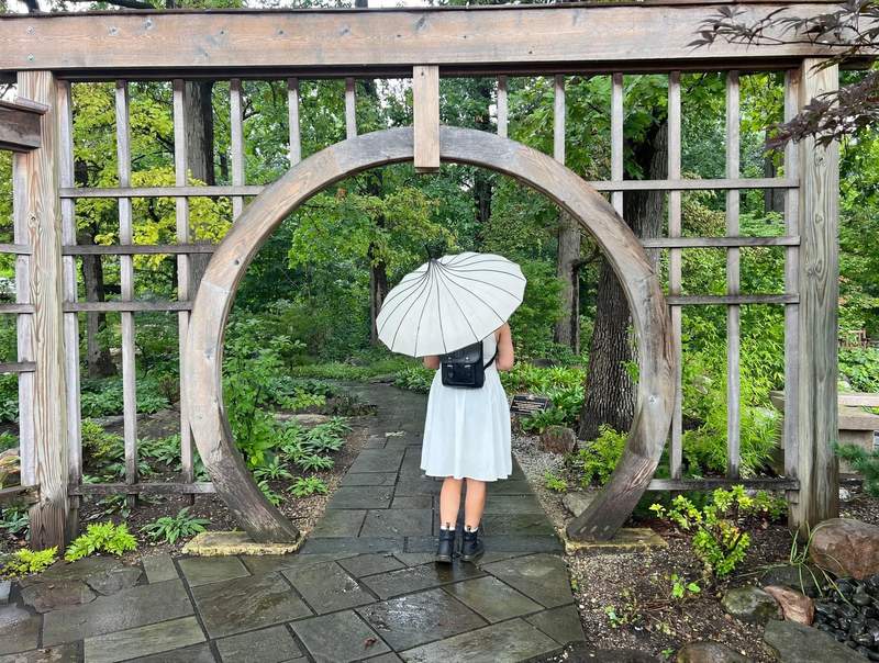 A photo of a girl with an umbrella taken by Meta Adventurer glasses in an Indiana garden.