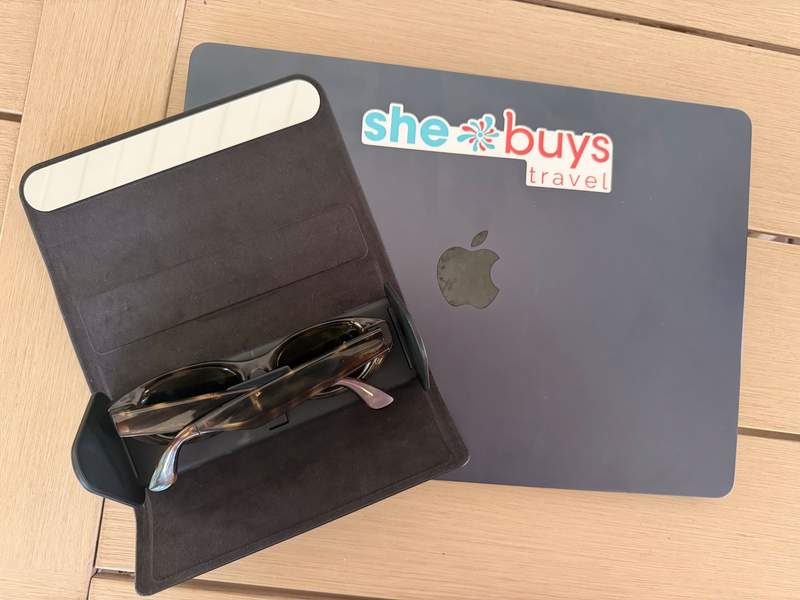Meta Starfire Kylie Edition glasses in dark tortoise in the folding charging case resting next to a laptop