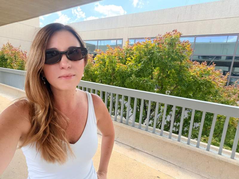 Woman wearing Meta Starfire Kylie Edition smart glasses in dark tortoise with chocolate lenses outside an airport