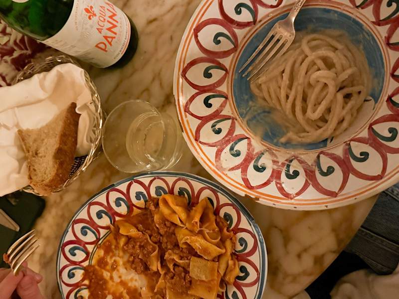Overhead Italian dinner table with hand painted ceramic plates and pasta