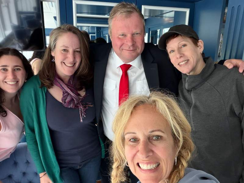 4 women and the captain of the Verity smiling for a photo.