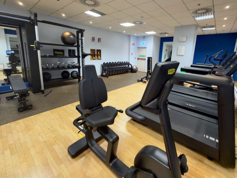Hilton Milan fitness center with treadmills, weight benches, dumbbells, kettlebells, exercise balls and strength-training equipment.