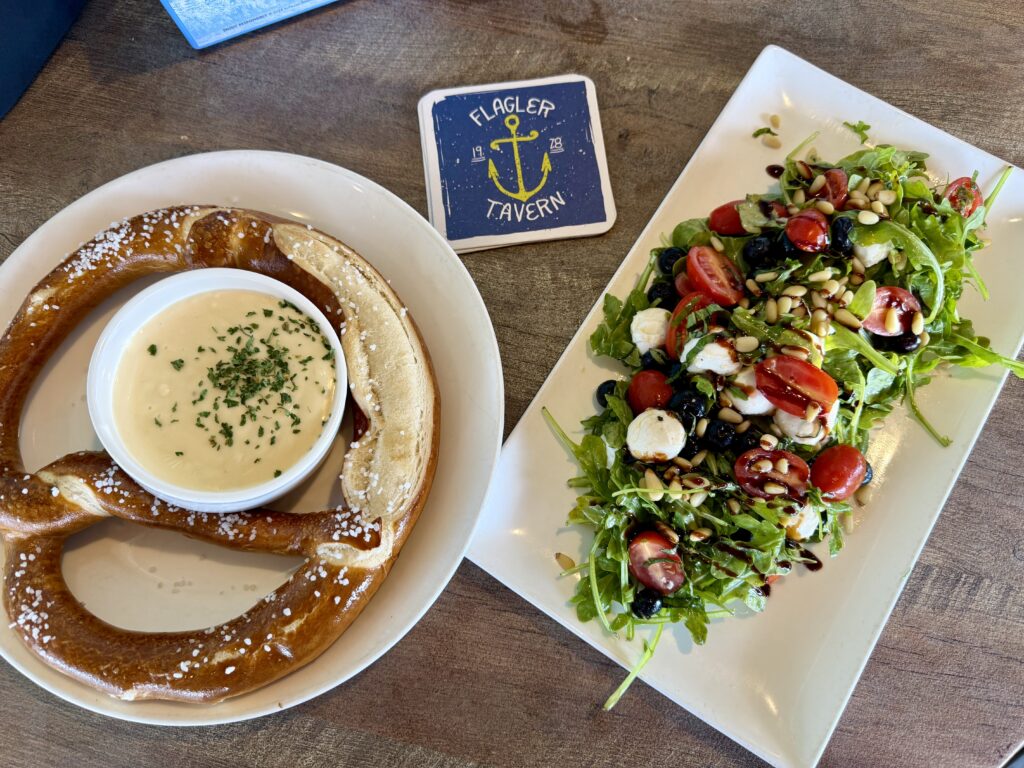 jumbo pretzel with dip and a plated salad