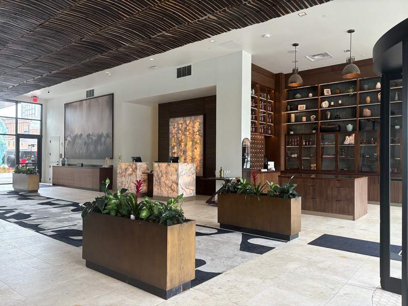hotel lobby with marble check-in desk and running horses mural