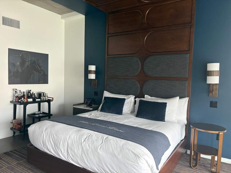 hotel room with navy walls and carved wood headboard