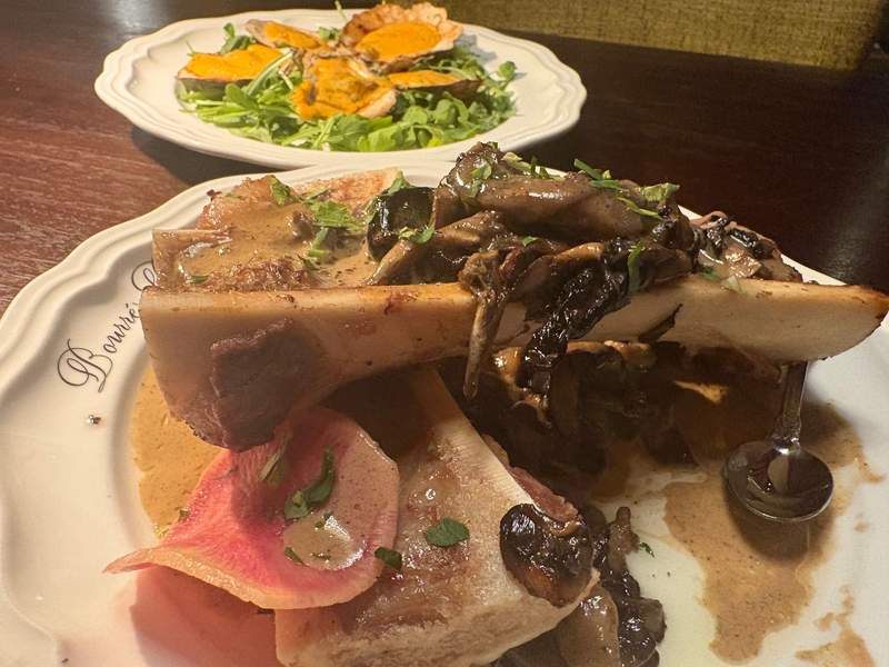 roasted bone marrow with mushrooms next to a plate of baked oysters