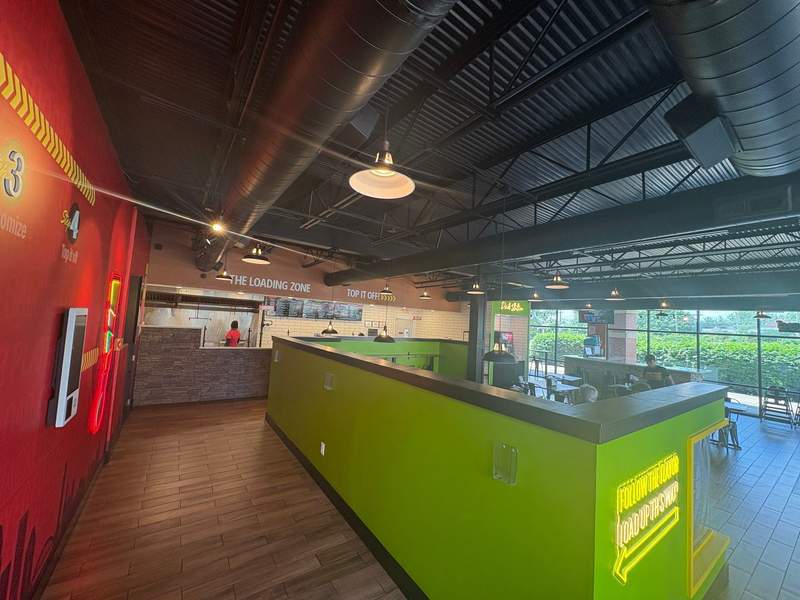 A photo of the brightly colored red-and-green interior walls of the Louisville restaurant Load It! with a build-your-own bar at the front.