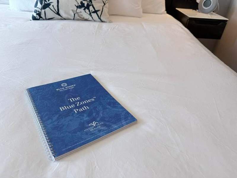 Blue Zones Workbook on a bed at the Sweetgrass Inn