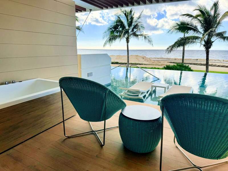 Private terrace with outdoor soaking tub and direct pool access overlooking the Caribbean Sea at Princess Grand Jamaica.