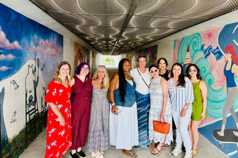 A group of women posing together by an art installation in Inlet Beach Florida