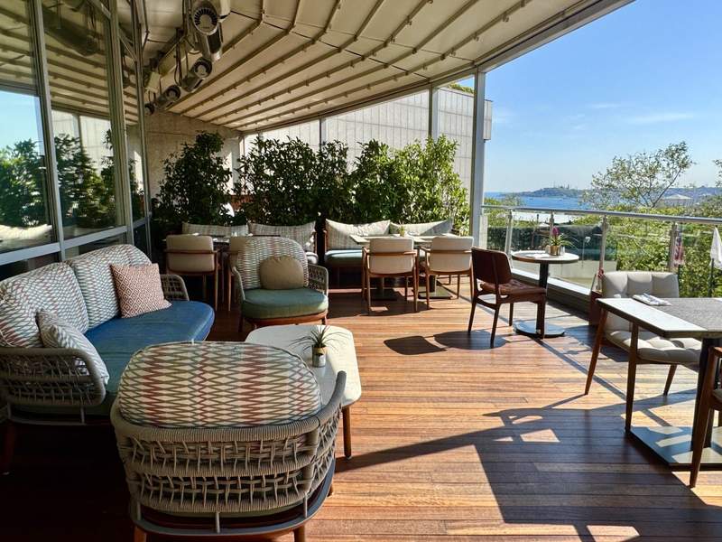 Executive lounge terrace at Conrad Istanbul Bosphorus, with comfortable seating and views across the Bosphorus Strait on a sunny day