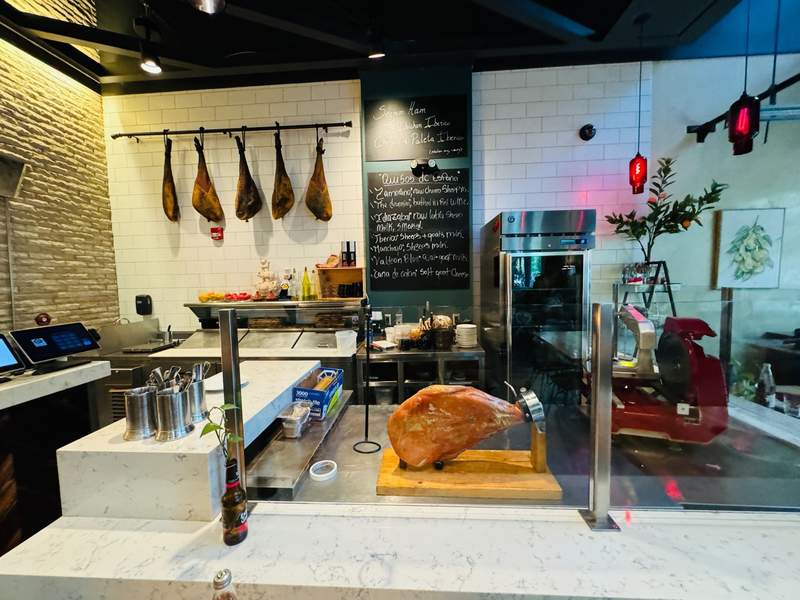 Spanish hams hang on the wall, and a deli counter has a Serrano ham ready to slice.
