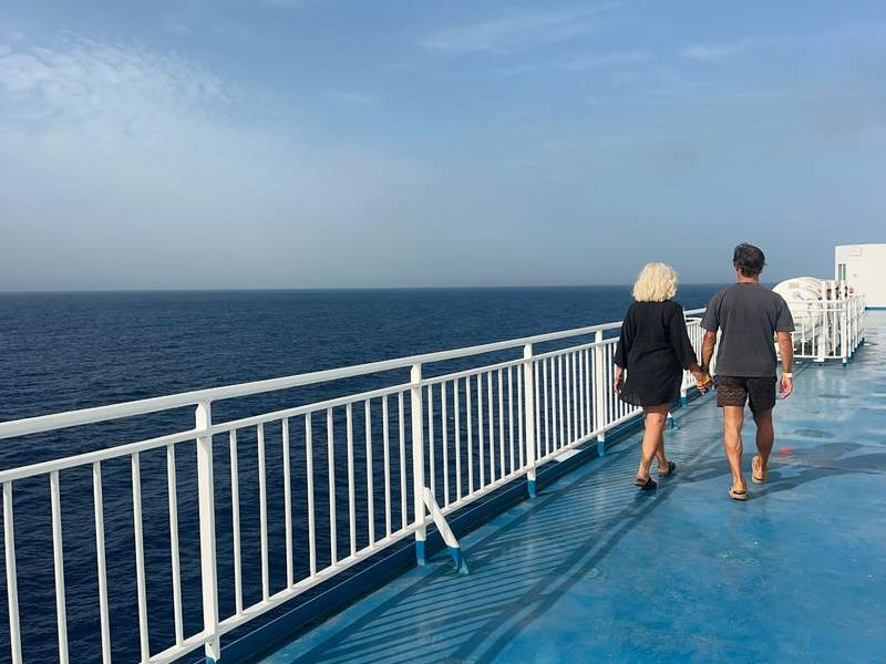 Couple walking on the outdoor deck of a ferry to Tenerife.