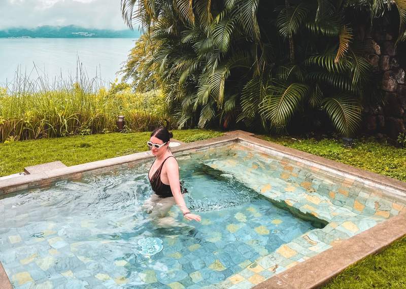 a woman inside a small plunge pool with an ocean view