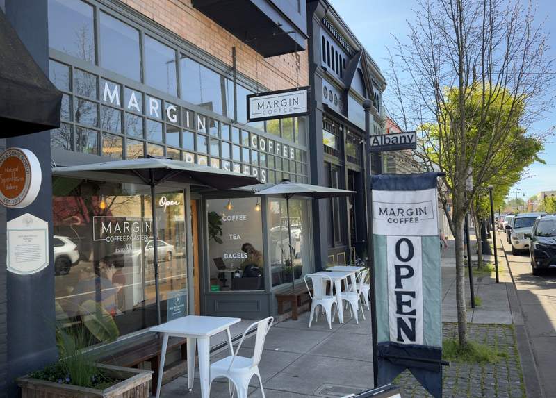 Margin Coffee storefront with outdoor tables and open sign in downtown Albany Oregon