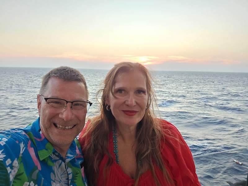 Couple posing for a selfie on Celebrity Ascent with the ocean behind them