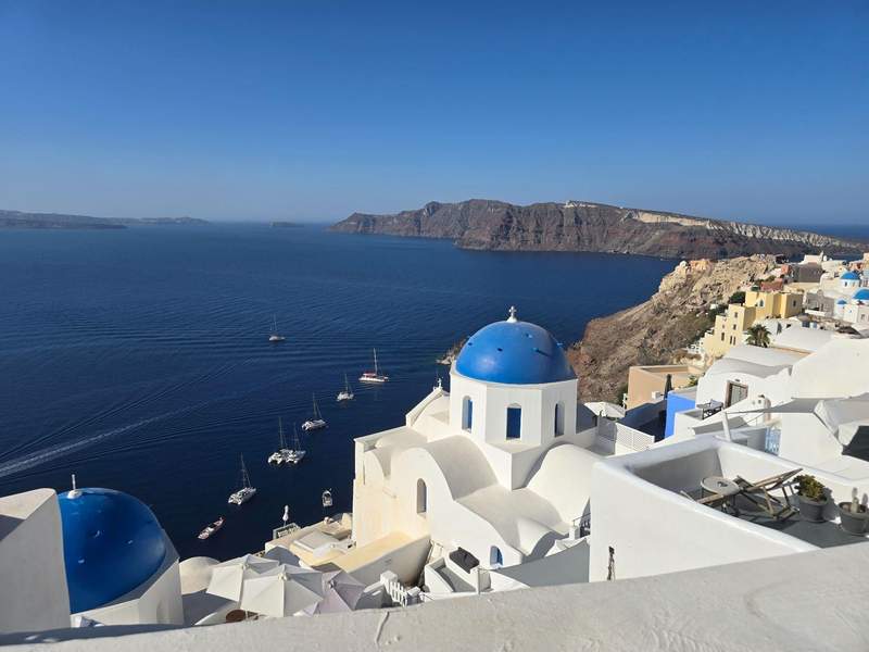 Whitewashed buildings and blue-domed church overlooking the sea in Santorini