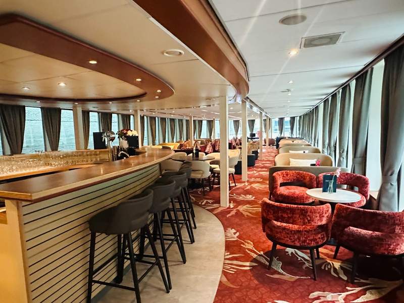 Lounge and bar aboard the MS Lisabelle with comfortable seating and large windows overlooking the Danube.