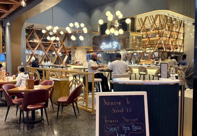 Dining area and sign for Shuck It oyster bar at Wind Creek Chicago Southland.