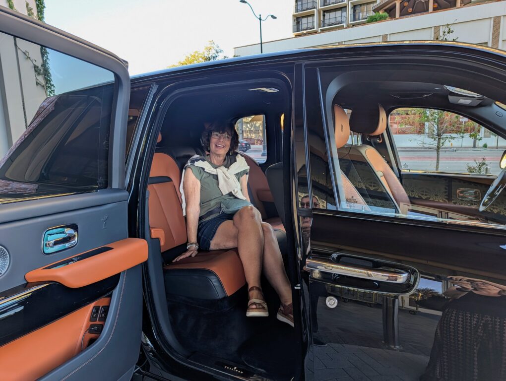 Smiling woman sits inside a Rolls-Royce SUV owned by The Monarch San Antonio hotel