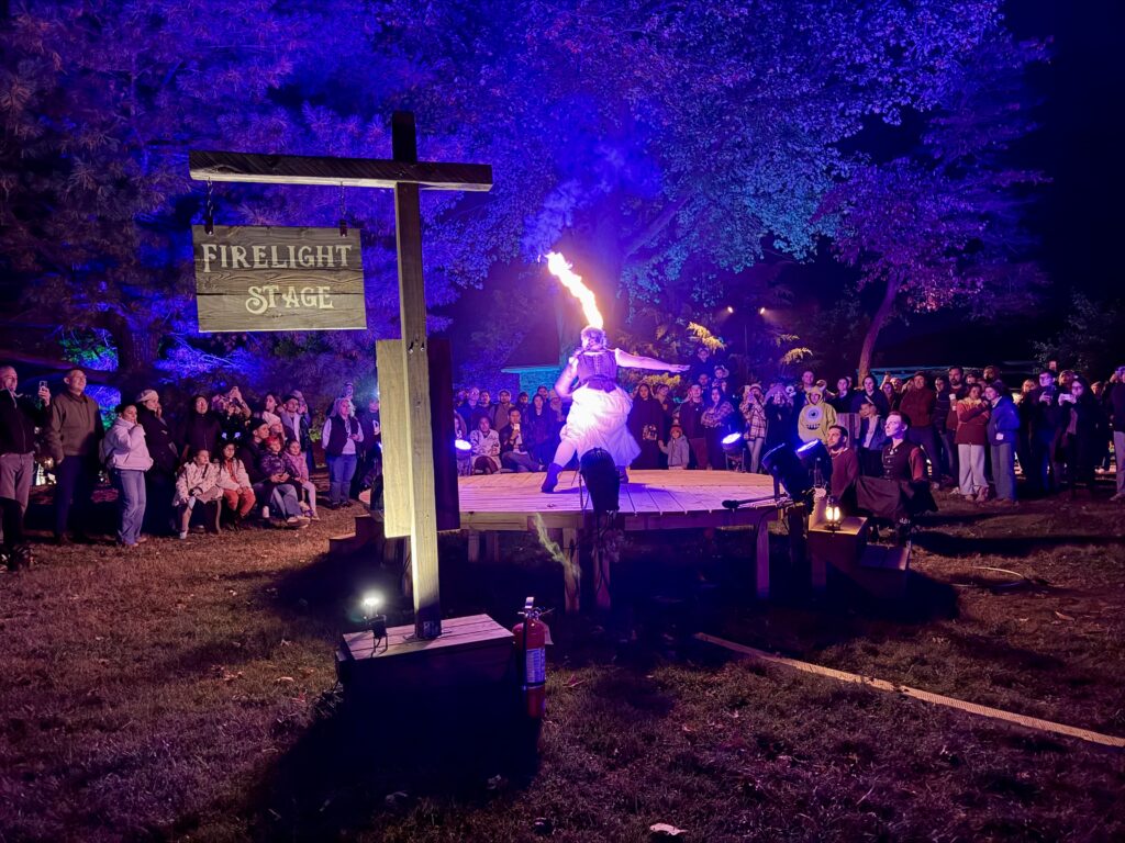 A woman with a firelit sword performing at Twilight Village in Sleepy Hollow